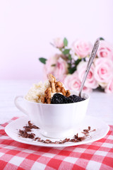 Dessert with prunes in cup with bouquet of roses
