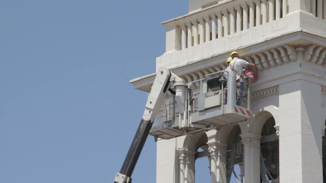 masons do maintenance work of a church with a boom lift - crane - worker