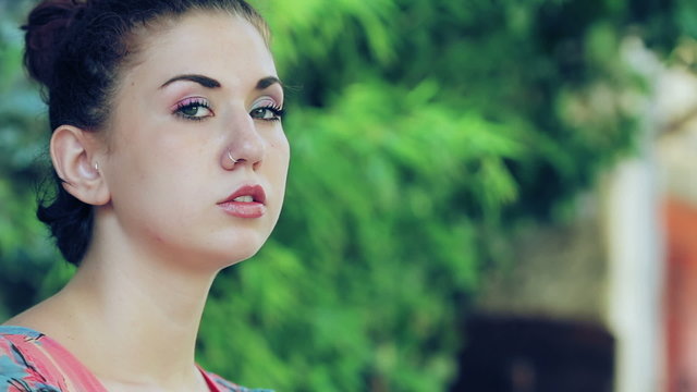 beautiful woman lights a cigarette and smokes Looking at the Camera