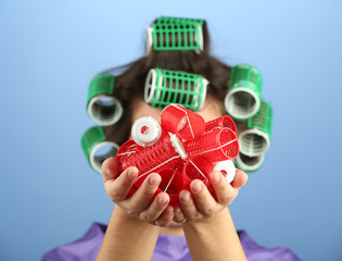 Girl in hair curlers on colorful background