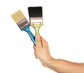 Paintbrushes in male hand isolated on white