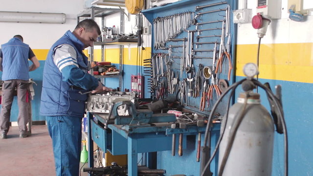 engine desk - two auto mechanics at the work - dolly