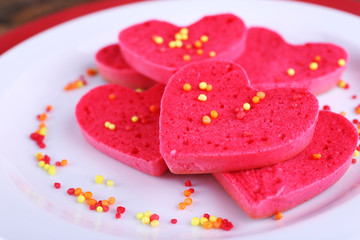 Cookies in form of heart on plates background