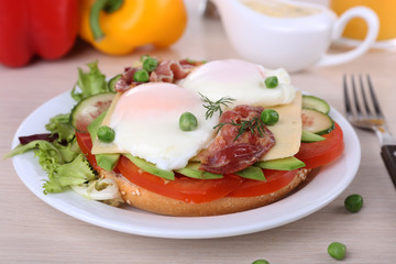 Sandwich with poached eggs, bacon and vegetables