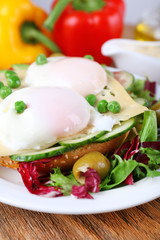 Sandwich with poached eggs, cheese and vegetables