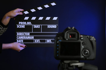 Hands with movie clapper board in front of camera