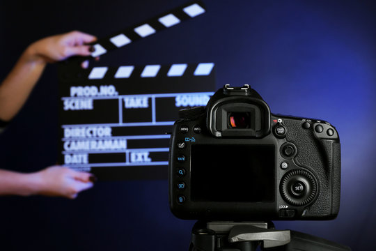 Hands with movie clapper board in front of camera