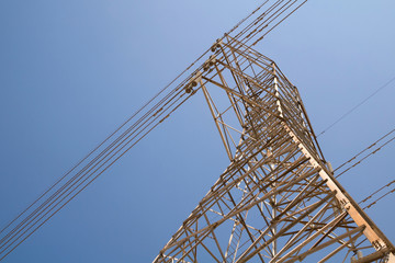 electric high voltage power post with blue sky background