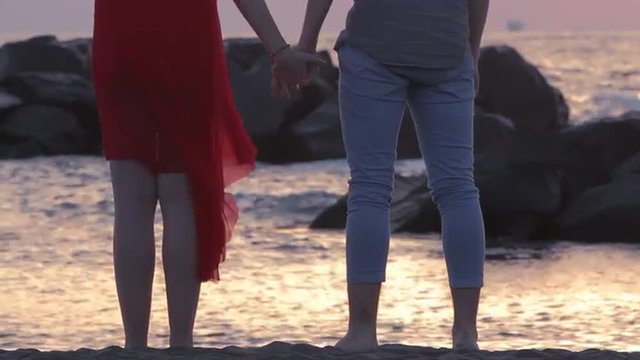 Young couple holding hands and looking at the horizon