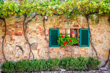 Fototapety  Piękne okno ozdobione kwiatami we Włoszech