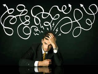 Depressed businessman sitting under drawn direction lines