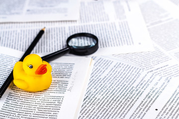 hoax symbol with rubber duck, pen and magnifying glass