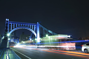 夜の清洲橋を走行する貨物トラック