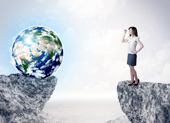 Businesswoman on rock mountain with a globe