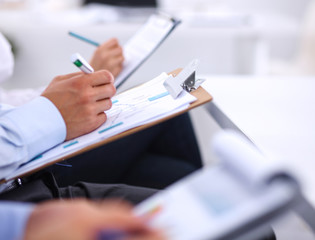 Business people sitting and writting at business meeting, in