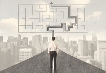 Businessman looking at road with maze and solution
