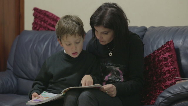 Mom is reading a book with her young son