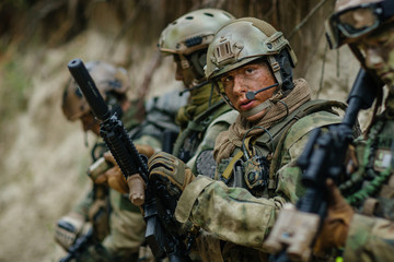 Fototapeta premium soldier holding a gun and looking at viewer