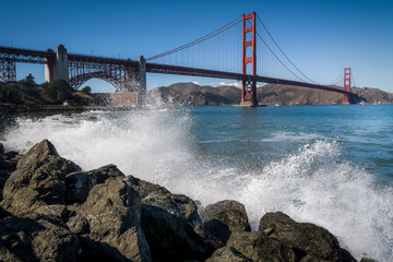 The Golden Gate Bridge with water splashing in the foreground.