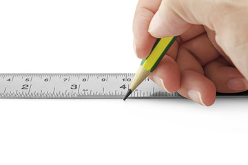Horizontal photo of female hand using ruler and pencil on white