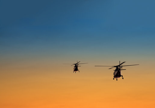 silhouette of two helicopters