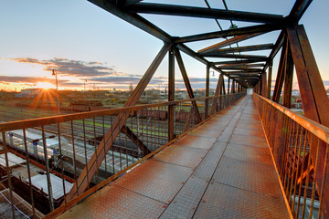 Foot bridge over railway at sunset