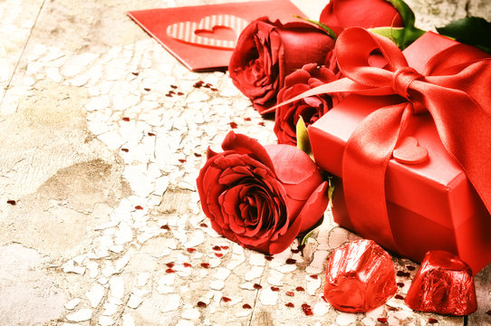 Valentine's setting with bouquet of red roses and present