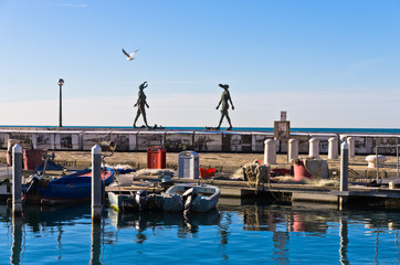 Fototapeta na wymiar Piran harbor with symbolic statues of Tartini theatre, Istria