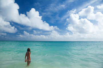 Obraz premium Girl enjoys summer day at the tropical beach.