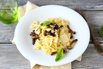 Delicious pasta farfalle with mushrooms in a plate