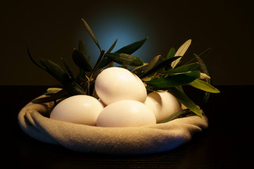 Pasqua. Uova bianche nel cestino con ramoscelli di ulivo