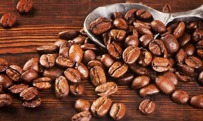 Coffee beans in spoon on  old  background