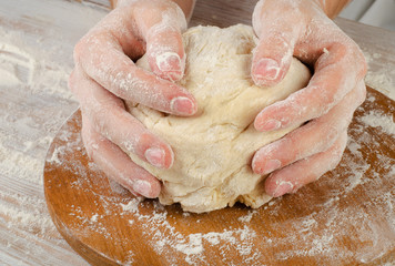 Woman  preparing dough  on   cutting board.