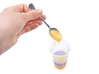 Spoon with vanilla pudding, baby food in hand on a white backgro