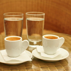 Two cups of coffee and two glasses of water