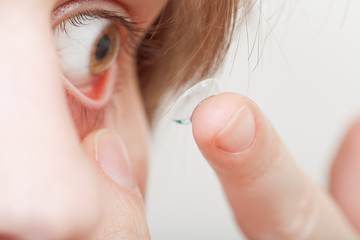 young woman inserting contact lens