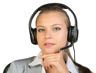 Businesswoman in headset sitting on chair, hand under chin