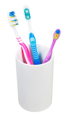 three toothbrushes in ceramic glass