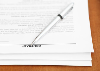 pages of sales contract and silver pen on table