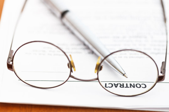 contract and silver pen through eyeglasses
