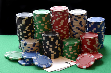 Red, blue, green, white and black poker chips pile and aces