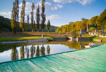 sunny day on forest lake and wooden board background
