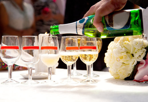 man fill in champagne glasses on wedding party