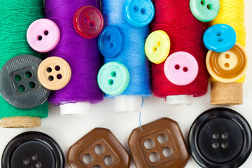 color buttons and thread bobbins on the white background