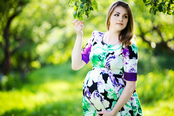 Beautiful pregnant woman in sunny park