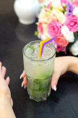 Woman hands with Mojito cocktail in a restaurant on a rustic woo