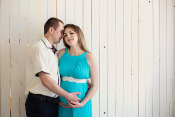 Portrait of a beautiful pregnant woman with husband at the backg