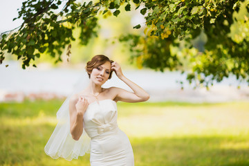 Obraz premium Adorable young caucasian bride in garden, sunny summer day.