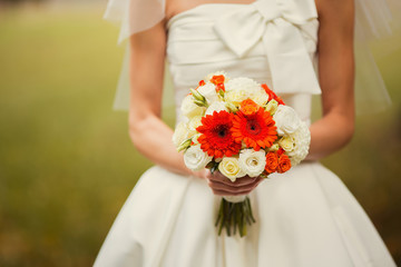 Obraz na płótnie Canvas bride holding wedding bouquet of various flowers.