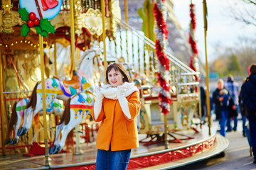 Fototapeta na wymiar Beautiful young girl near merry-go-round